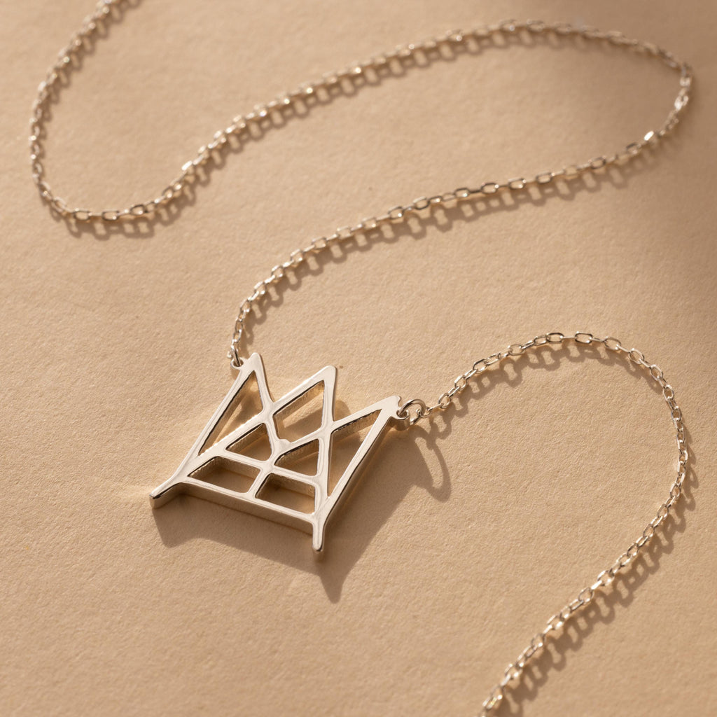 Modern Name Monogram Necklace featuring a gold chain and geometric crown-shaped pendant, ideal for those seeking personalized jewelry and contemporary necklace designs.