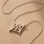 Modern Name Monogram Necklace featuring a gold chain and geometric crown-shaped pendant, ideal for those seeking personalized jewelry and contemporary necklace designs.