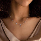 A woman wears the Ivy Diamond Station Necklace, its diamond accents offering a subtle sparkle.