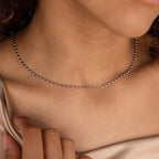 A woman in a beige top wears the delicate Oval Beaded Necklace.