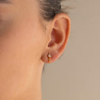 Close-up of a person's ear wearing the Diamond Kite Drop Earrings, featuring sparkling stones and vintage charm, set against a neutral background.
