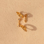 The Dainty Pave Earrings Set features sparkling pave accents and a chic design, displayed on a textured beige background—ideal for fans of elegant earrings.