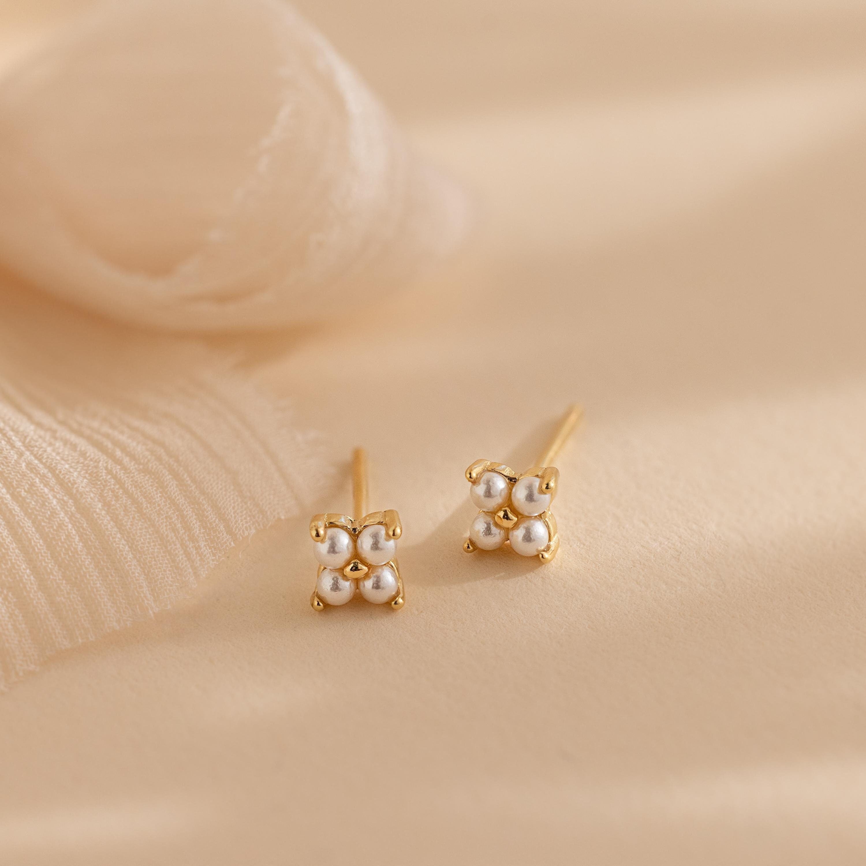 The Pearl Ivy Flower Studs feature gold settings with clusters of small white pearls arranged in a floral design—perfect for weddings or adding an elegant, floral touch to any outfit.