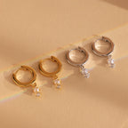 Our Dangling Pearl Diamond Huggies feature gold and silver hoops adorned with delicate pearls and sparkling crystal charms, adding a touch of timeless elegance to any look.