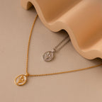 The Pearl Tulip Necklace in Sterling Silver features a delicate floral pendant, showcased on a beige surface beside a wavy ceramic object.