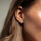 Close-up of a woman's ear wearing Pearl Flower Studs—delicate, floral-inspired earrings that bring elegant charm to any outfit.