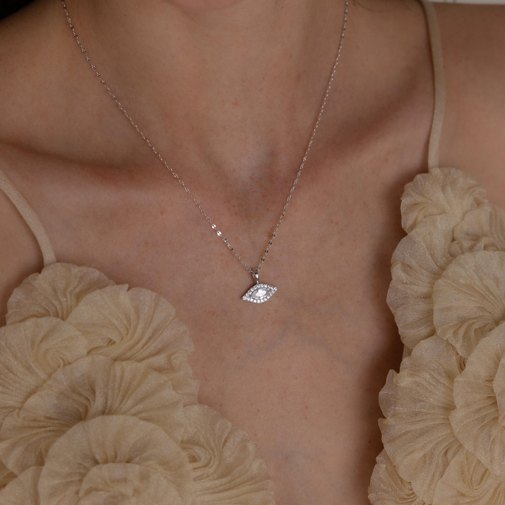 Model wears silver mirror chain with dangling Pave Evil Eye Charm
