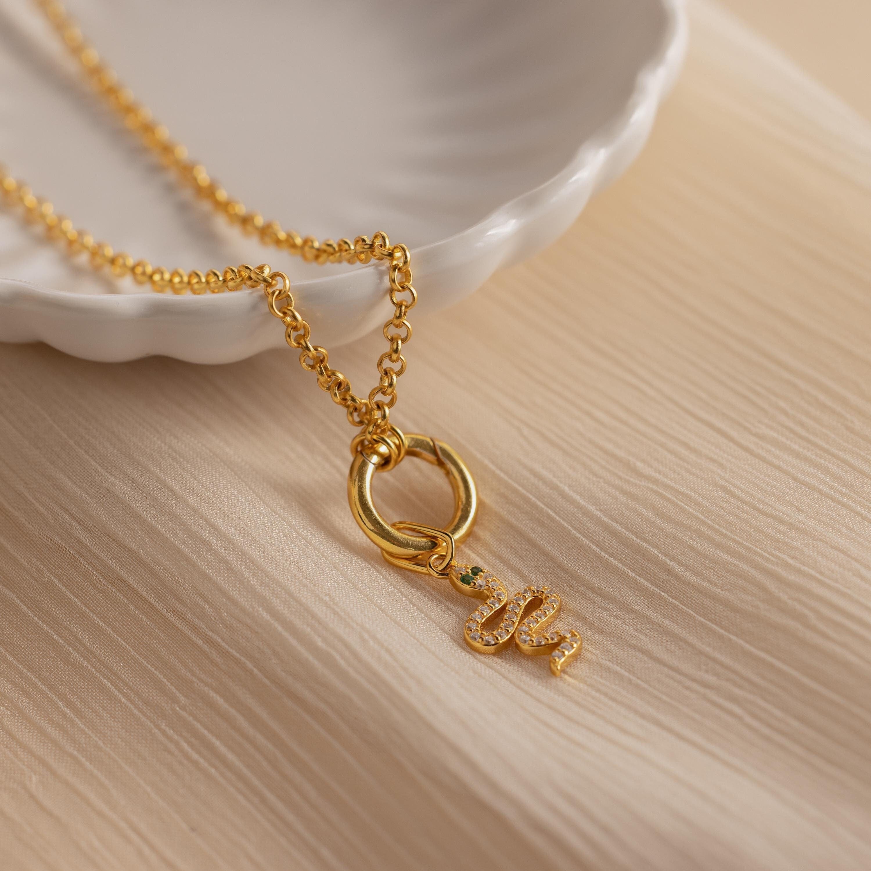 A gold diamond snake charm attached to a rolo circle necklace