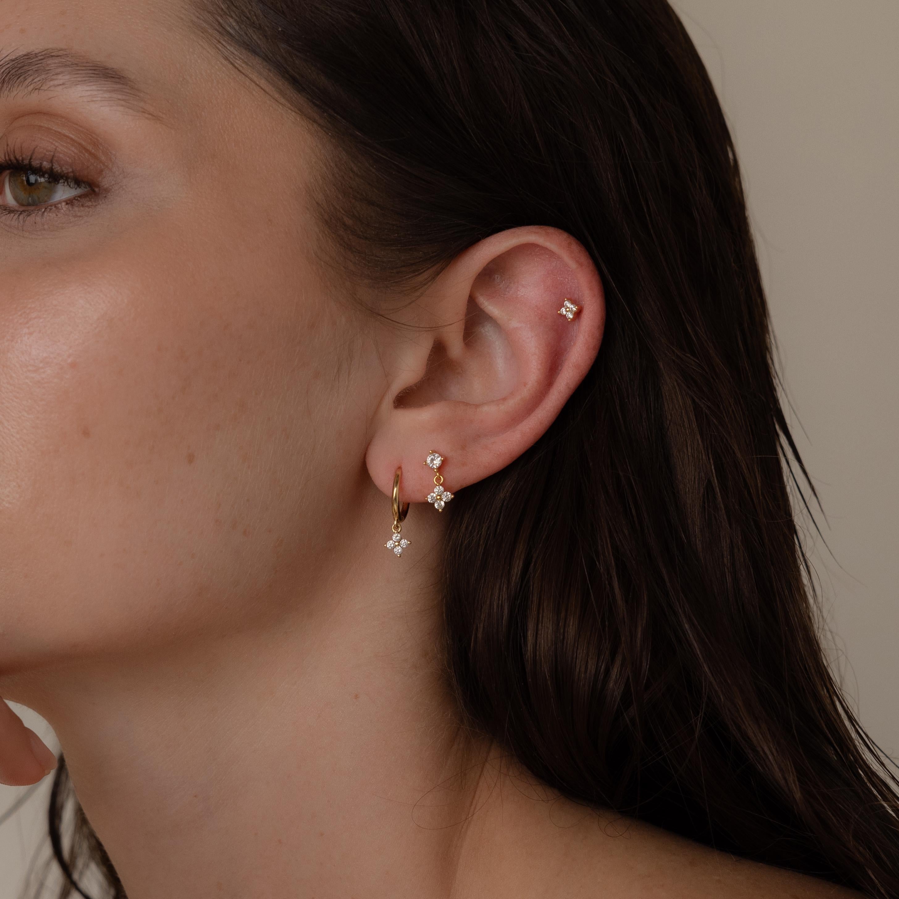 Close-up of a woman’s ear adorned with gold and diamond Ivy Flower Flat Back Studs on the lobe and upper ear—an elegant choice, perfect as a Mother’s Day gift.