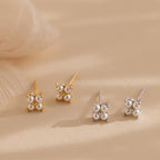 The Pearl Ivy Flower Studs set includes two pairs of stud earrings—one gold, one silver—with clusters of three small spheres, resembling delicate floral designs. Perfect as subtle wedding earrings.