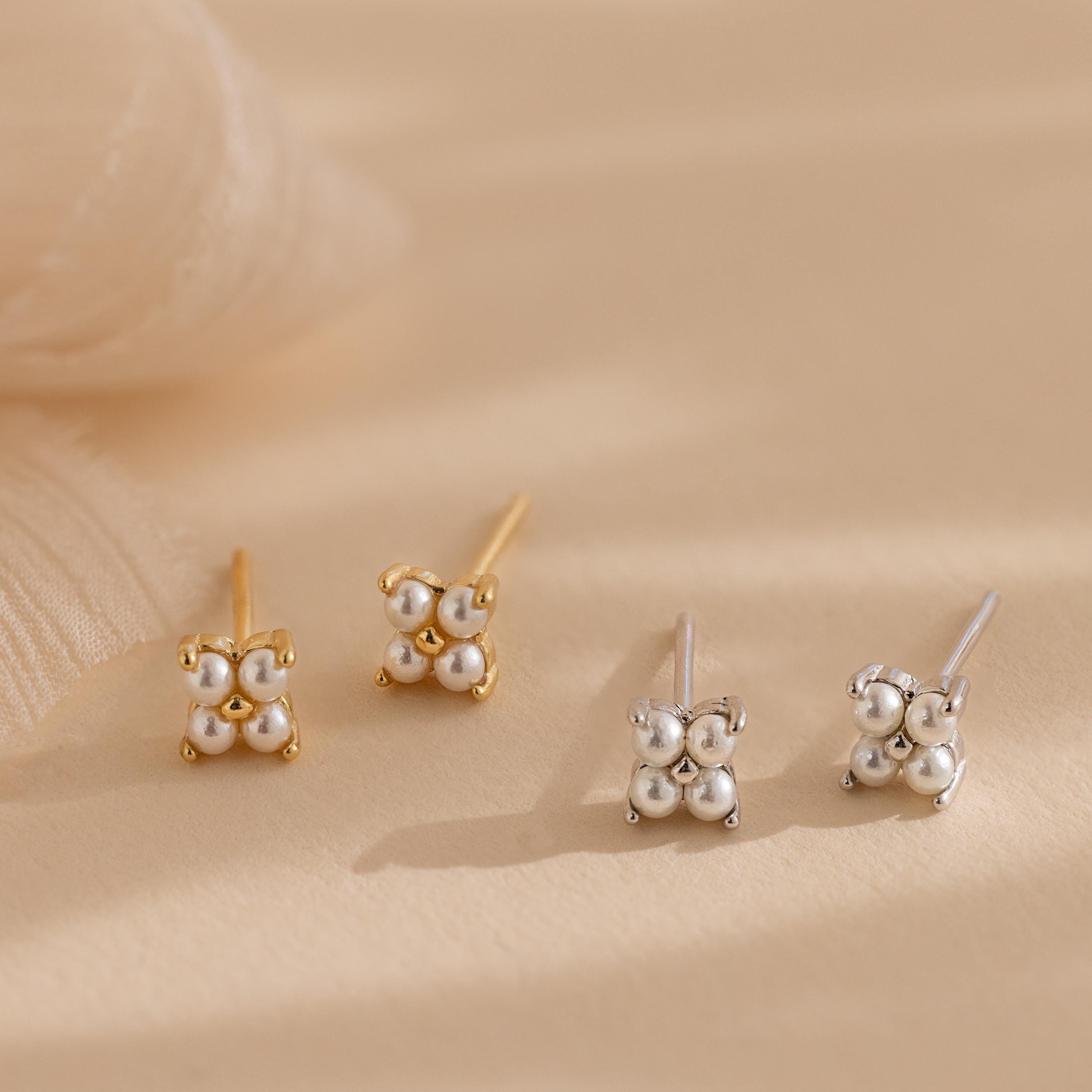The Pearl Ivy Flower Studs set includes two pairs of stud earrings—one gold, one silver—with clusters of three small spheres, resembling delicate floral designs. Perfect as subtle wedding earrings.