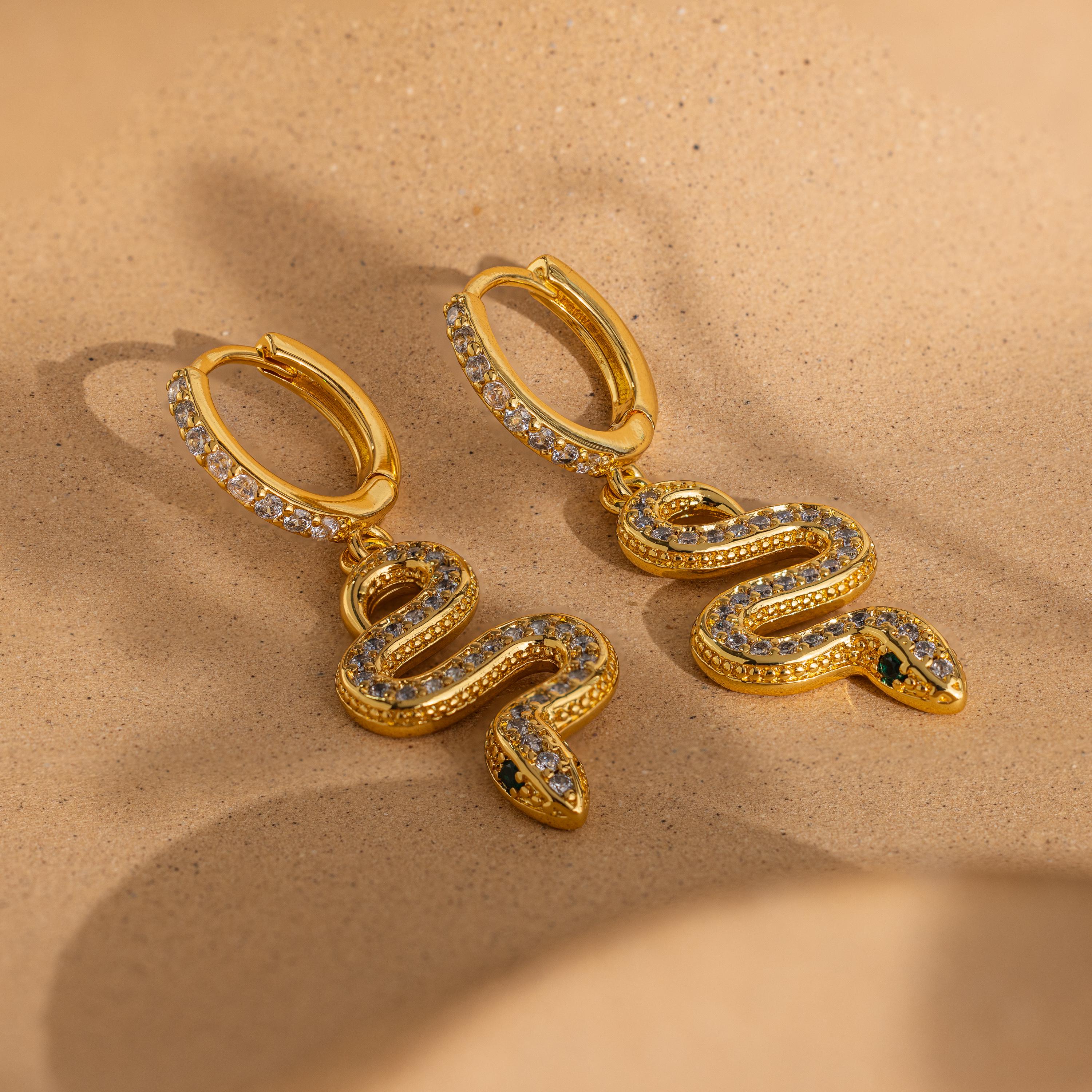 The Pave Snake Charm Hoops feature a shimmering gold design with sparkling diamonds, adding slithering elegance to any look.