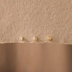 Three Marquise Opal Flat Back Studs are displayed on textured beige paper—elegant gold earrings that make a perfect gift for her.