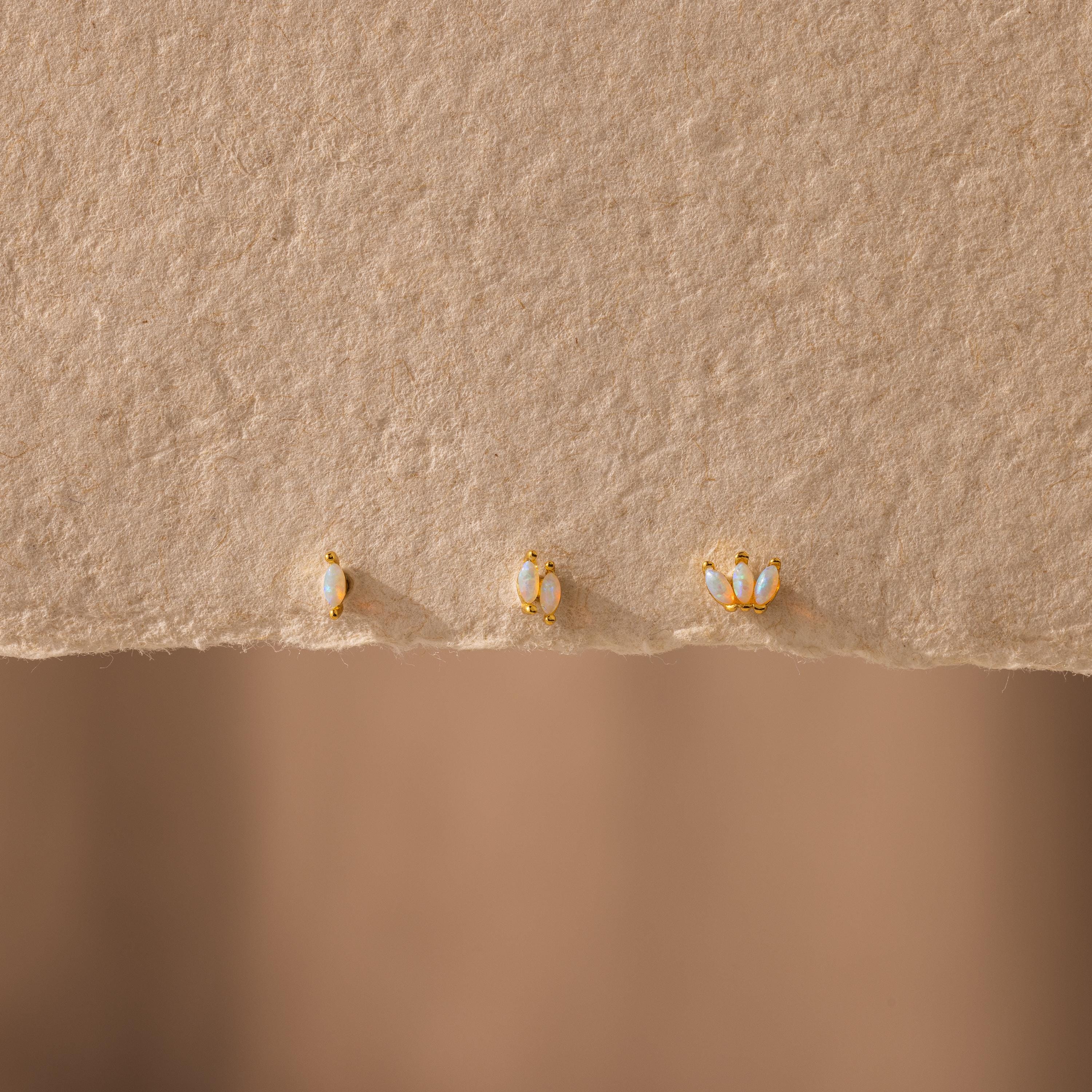 Three Marquise Opal Flat Back Studs are displayed on textured beige paper—elegant gold earrings that make a perfect gift for her.