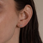Close-up of a woman's ear adorned with Marquise Diamond Climbers, delicate silver earrings shaped like leaves—perfect for pairing with diamond studs or as refined wedding jewelry.