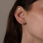 A woman's ear adorned with Opal Heart Flat Back Studs, adding a delicate touch to her look—ideal for birthstone jewelry lovers or anyone seeking elegant gemstone earrings for daily wear.