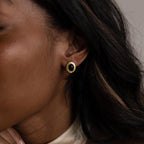 Close-up of a woman with dark hair and tan skin wearing Vintage Oval Black Studs—ideal retro statement stud earrings to enhance your style.