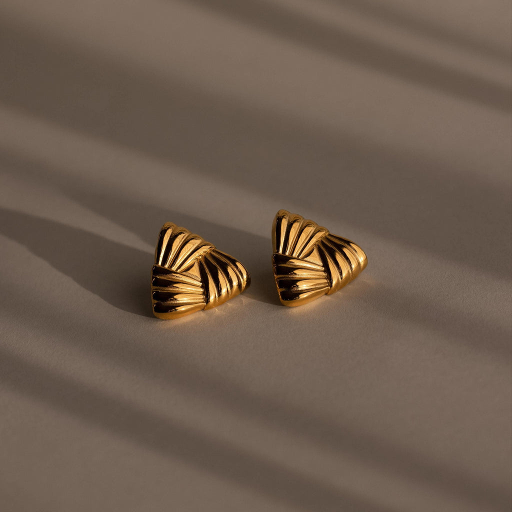 Bold Triangle Knot Studs are gold, triangular textured earrings displayed on a neutral surface with soft shadows—perfect chunky studs for anyone wanting a striking statement accessory.