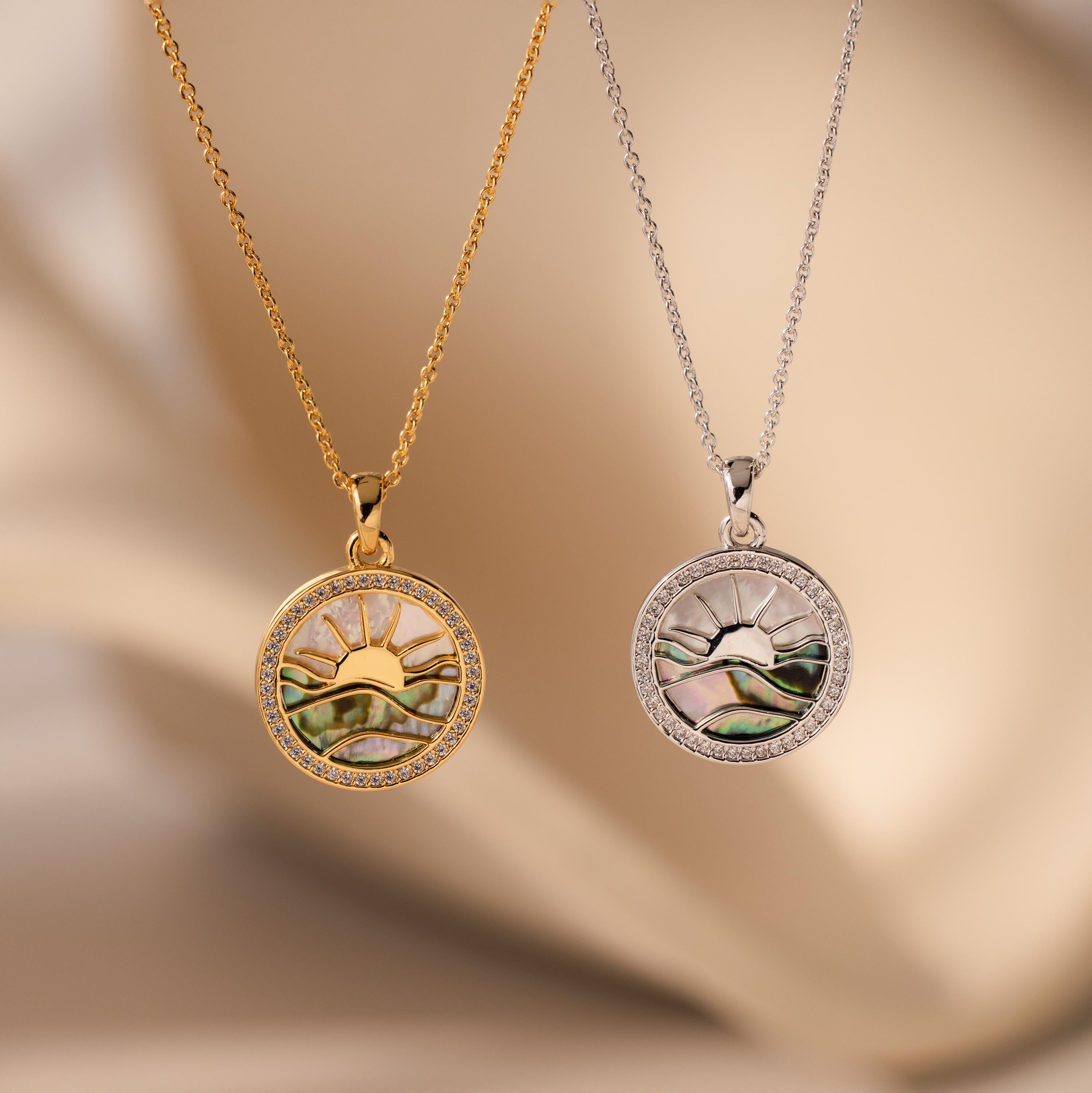 The Abalone Sunrise Pendant Necklace, available in gold and silver with a sun and mountain design, makes a stunning pair—perfect for layering with your favorite pavé diamond necklace.