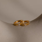 Two Diamond Ribbed Huggies, featuring a ribbed texture and small diamonds, are shown on a smooth beige curved surface.