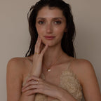 Model wears a mirror chain with Pave Evil Eye Charm and other charms. The set is paired with gold diamond rings for a complete look