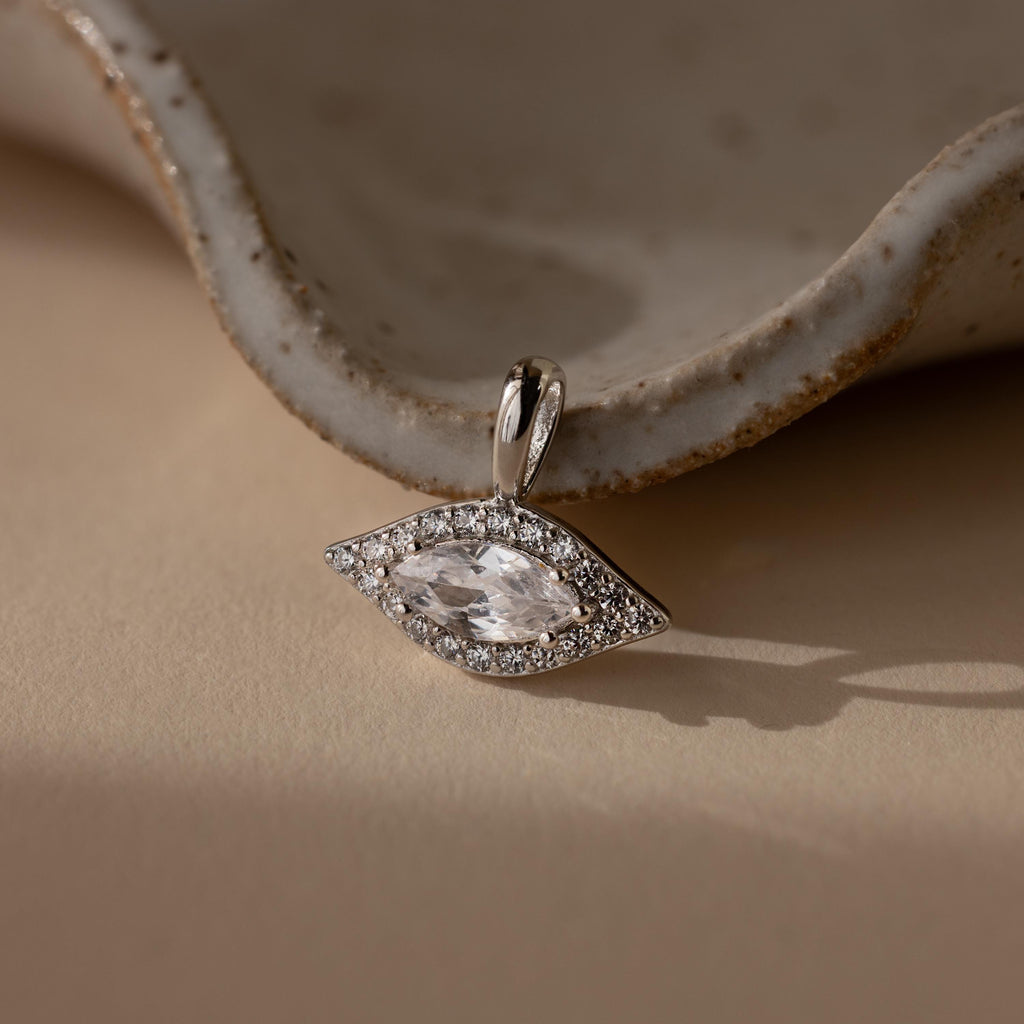 Silver Pave Evil Eye Charm. The design features a marquise diamond in the center with pave gemstones surrounding it in the shape of an eye.