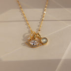 Gold Pave Evil Eye Charm on mirror chain, paired with a moonstone signet charm and diamond charm 