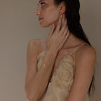 A wide shot of a model with a gold diamond snake charm hanging from a satellite bracelet