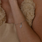 Model wears a silver diamond snake charm attached to a satellite bracelet
