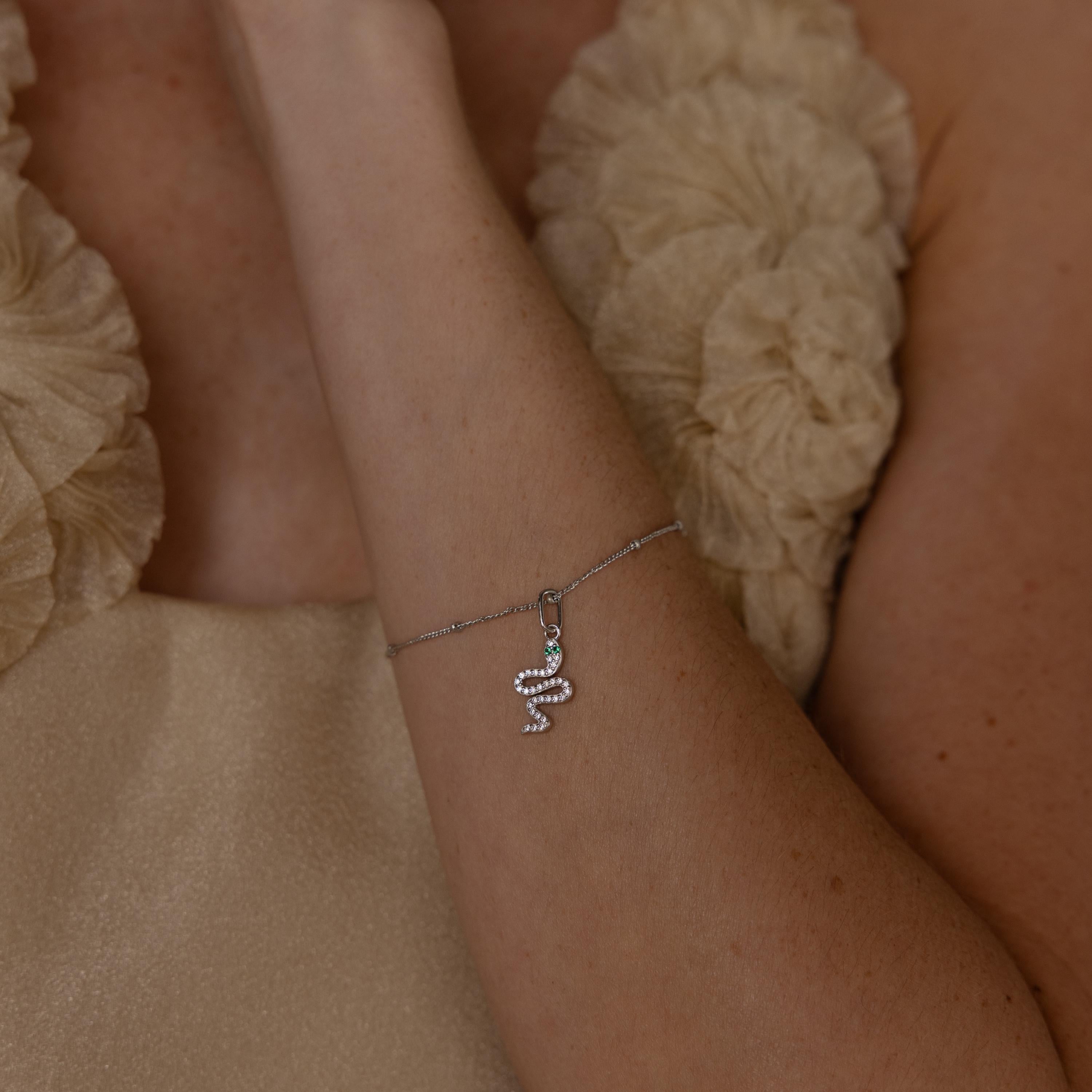 Model wears a silver diamond snake charm attached to a satellite bracelet