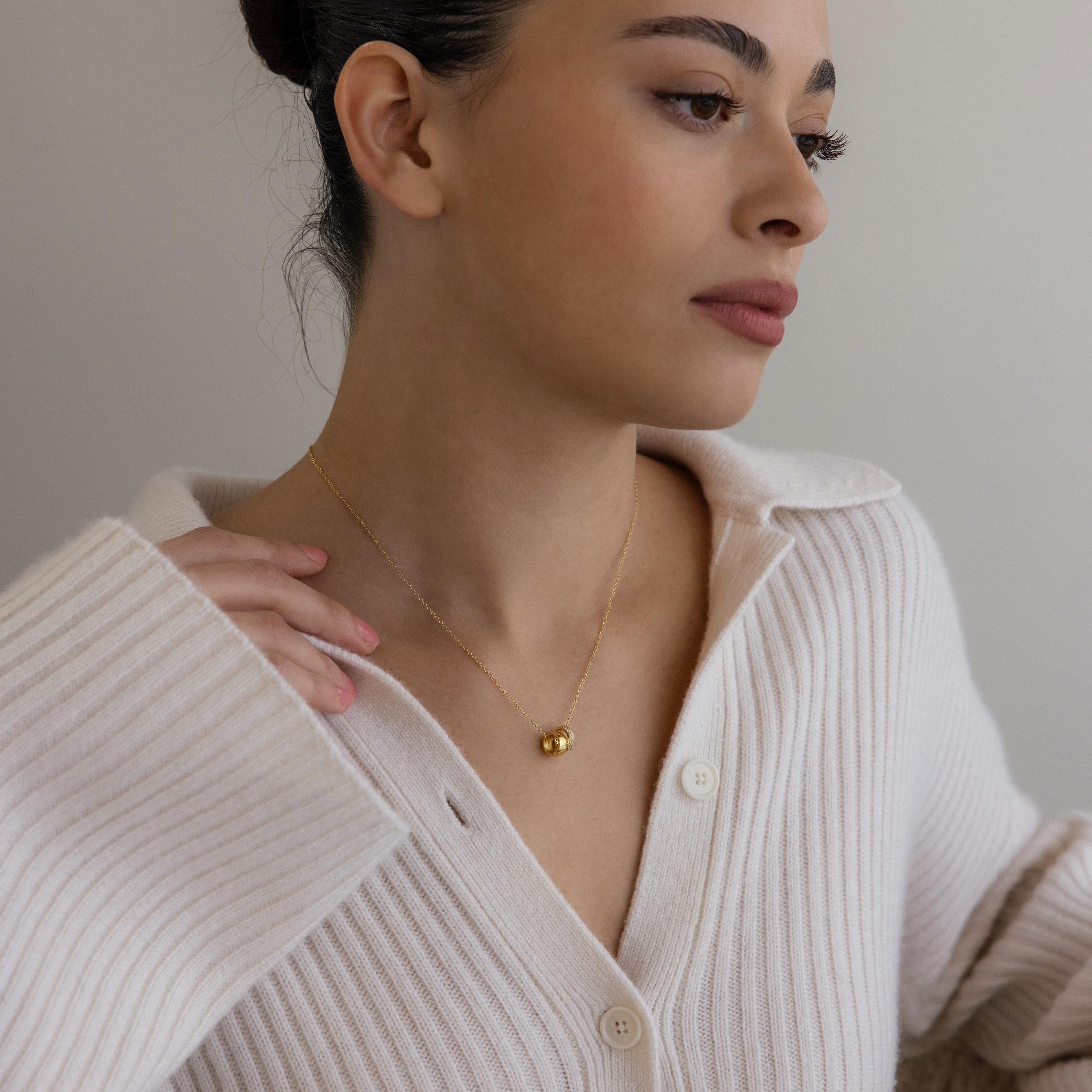Woman in a cream ribbed sweater wears the Pave Duo Circle Necklace, its elegant jewelry design catching the light as she gazes thoughtfully to the side.