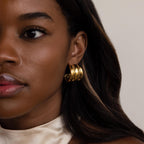 Close-up of a woman in a cream satin top and smooth dark hair, wearing Chunky Triple Hoops.