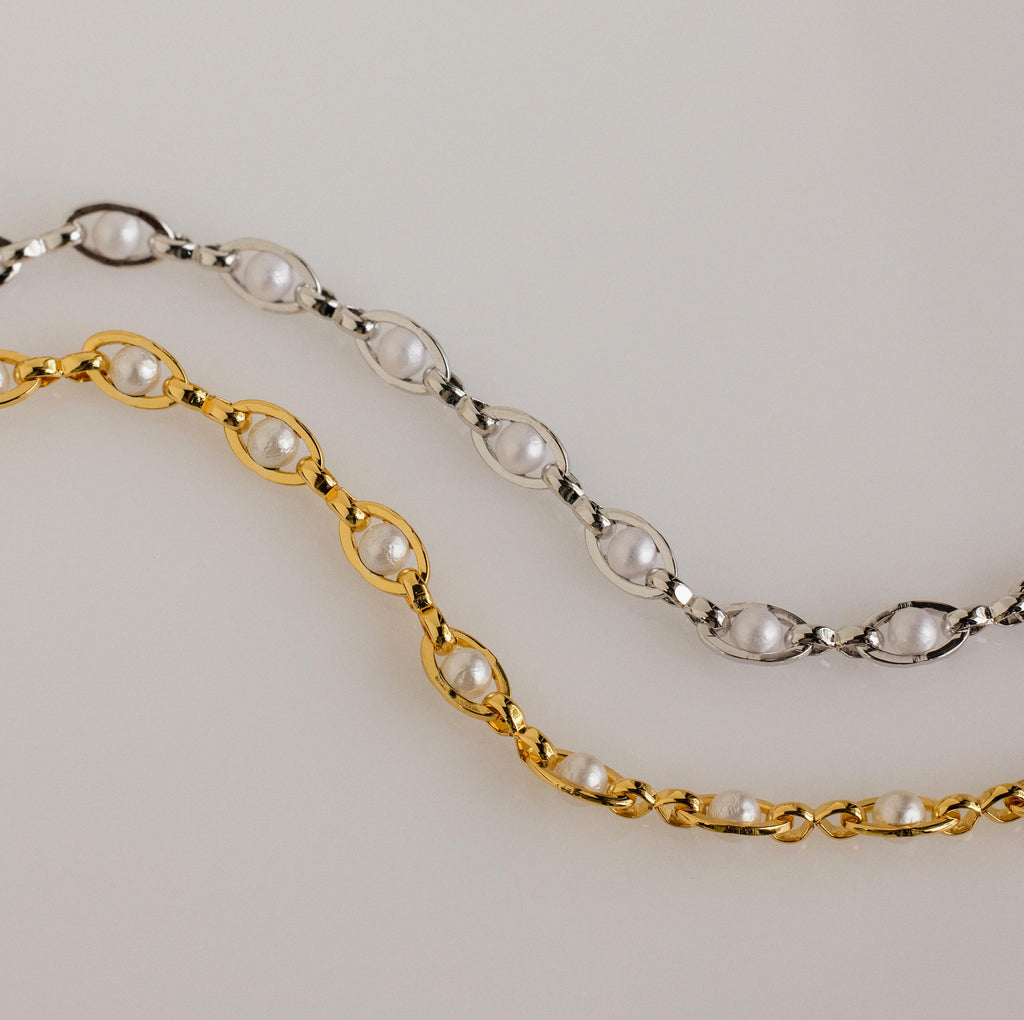 The Eternity Pearl Bracelet, available in gold and silver, features elegant pearls and delicate infinity chain details, beautifully displayed on a light background.