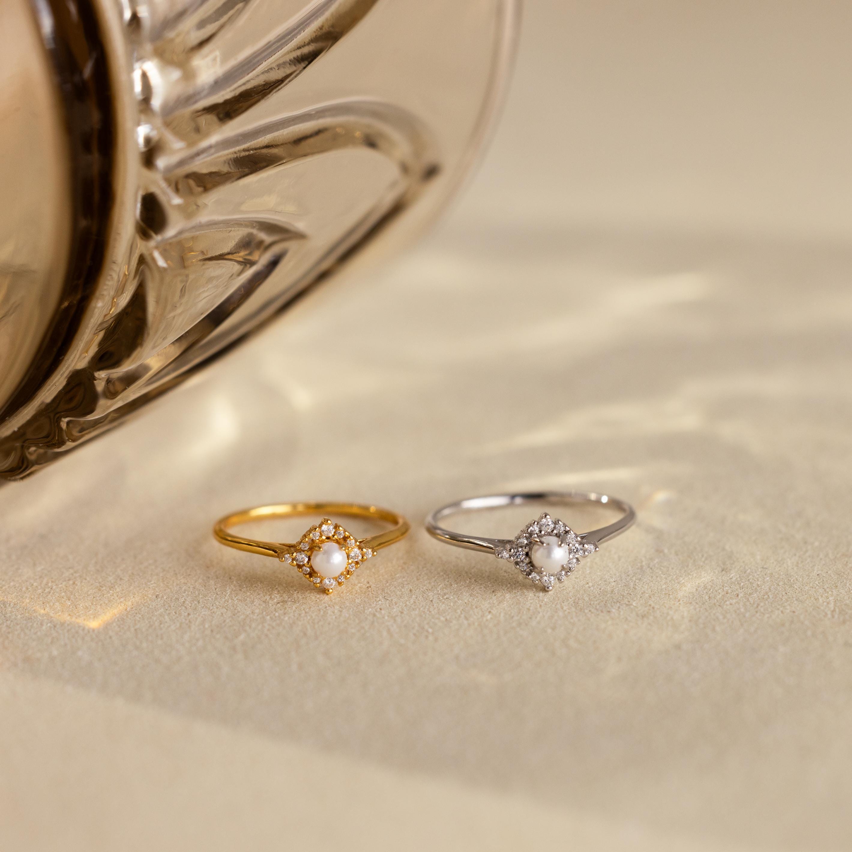 The Vintage Pave Pearl Ring in Sterling Silver, featuring a delicate central pearl, makes a perfect Christmas gift and is beautifully displayed on a light textured surface.