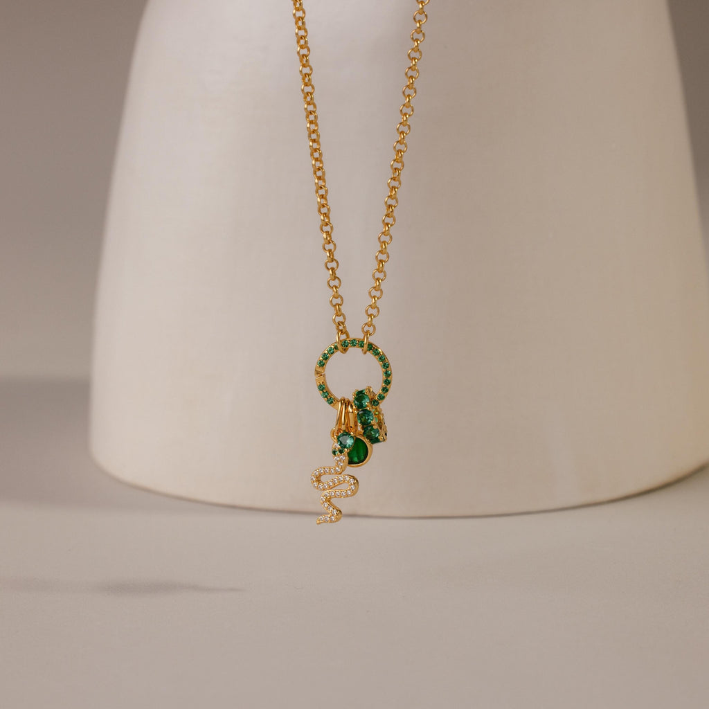 The Pave Emerald Charm Clip, a gold necklace charm accented with green pavé and elegant details, is displayed against a neutral background—ideal for anyone who loves stylish, personalized jewelry.