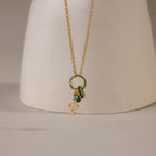 The Pave Emerald Charm Clip, a gold necklace charm accented with green pavé and elegant details, is displayed against a neutral background—ideal for anyone who loves stylish, personalized jewelry.