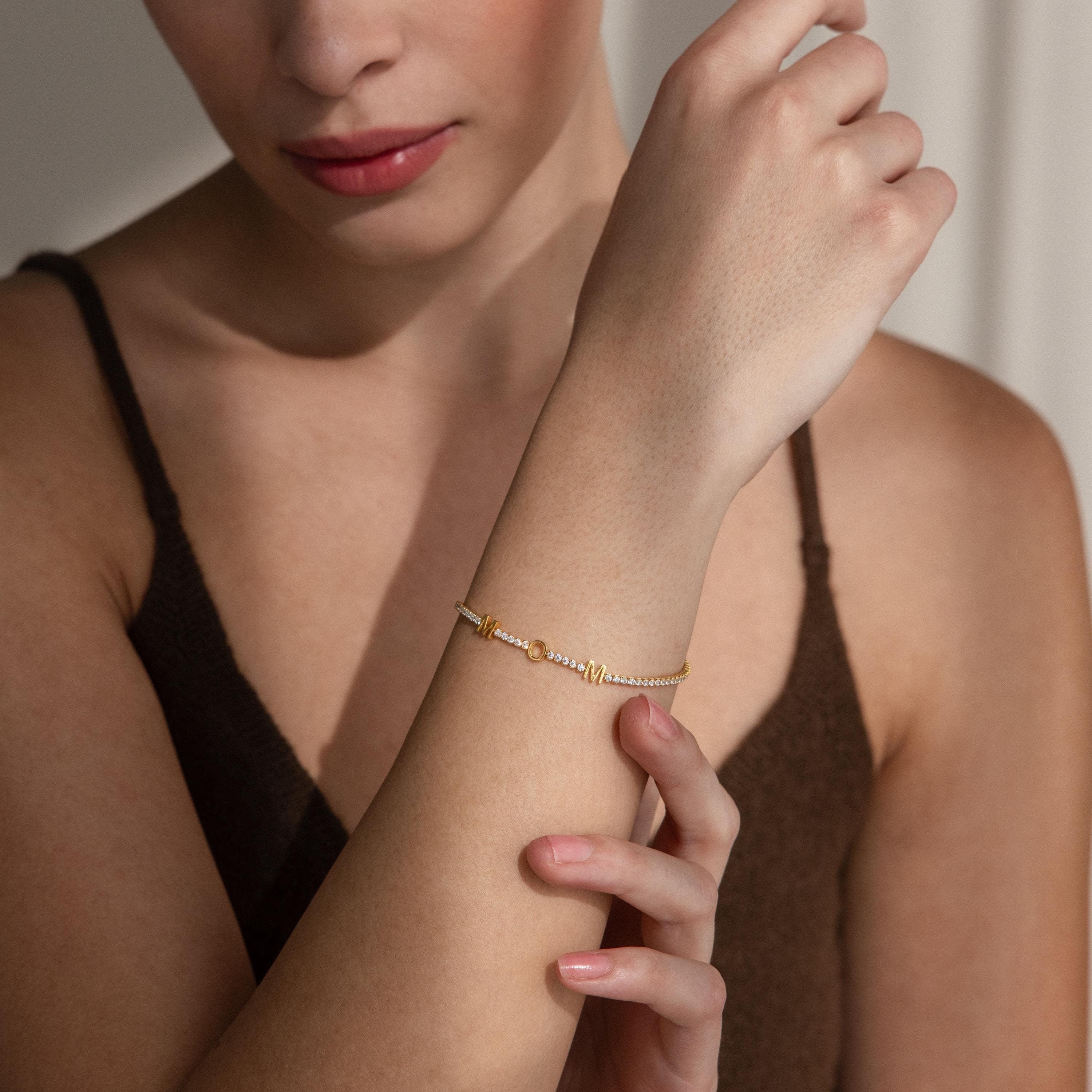 A woman models the Mama Tennis Letter Bracelet—a delicate, elegant, and customizable piece of jewelry perfect for gifting.