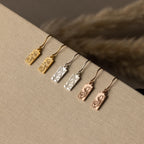 The Rectangle Birth Flower Earrings are available in gold, silver, and rose gold with floral engravings, beautifully displayed on beige fabric for a personalized jewelry touch.