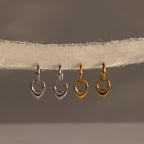 Two silver and two gold heart-shaped charms hang on a textured, off-white fabric string—perfect for pairing with your favorite Bold Teardrop Hoops for a charming, coordinated look.