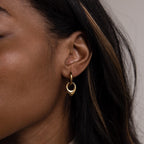 Close-up of a woman's ear with brown, highlighted hair wearing Bold Teardrop Hoops—versatile gold earrings perfect for any occasion.
