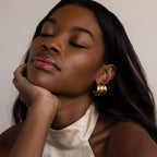 With her eyes closed, a woman wears the Chunky Triple Hoops, their bold design accentuating her serene expression.