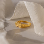 The Duo Initial Heart Ring features two heart shapes engraved with initials, beautifully displayed on soft, white fabric.