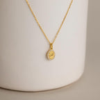 The Pave Initial Pendant Necklace features a round pendant engraved with the letter A, bordered by sparkling white stones for a personalized, elegant, and timeless look.