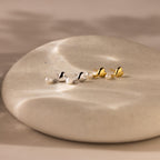 Heart Pearl Drop Earrings are displayed on a smooth, round stone surface, ideal for anyone seeking elegant and sophisticated pearl earrings.