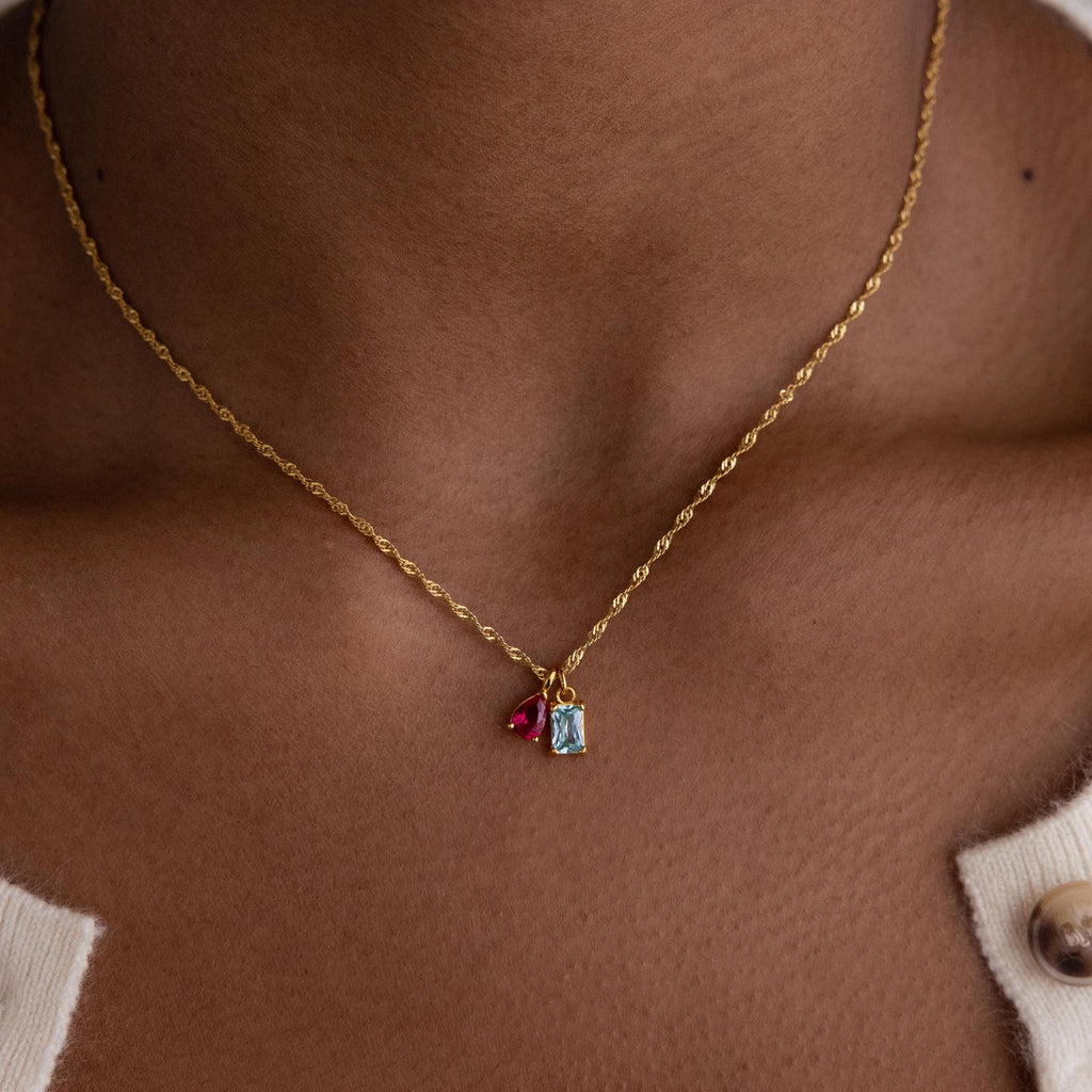 Model wearing a gold Singapore Twist Necklace with Pear & Baguette Birthstone Charm Set