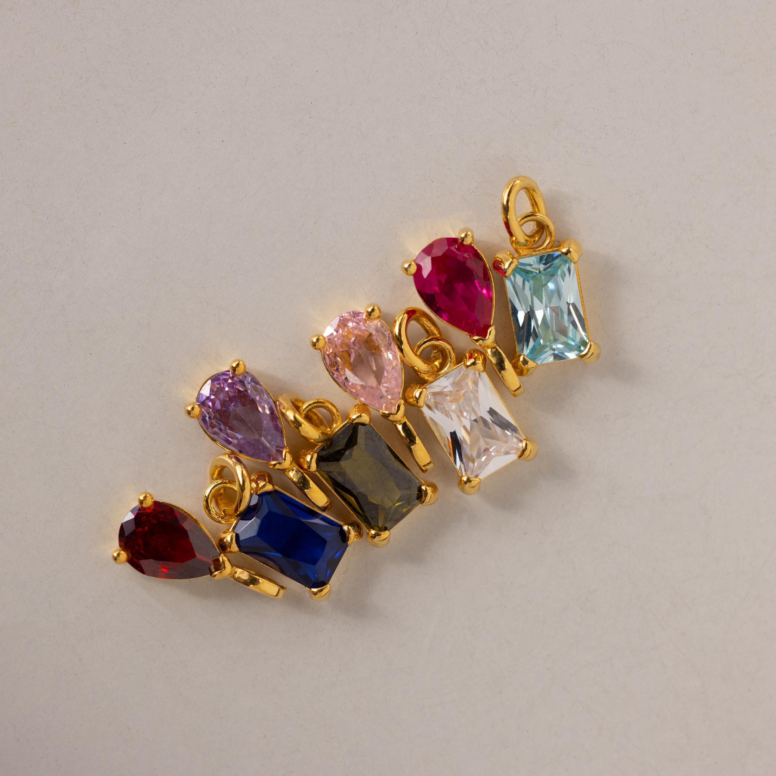 Multiple Pear & Baguette Birthstone Charms in different stone colors arranged side by side