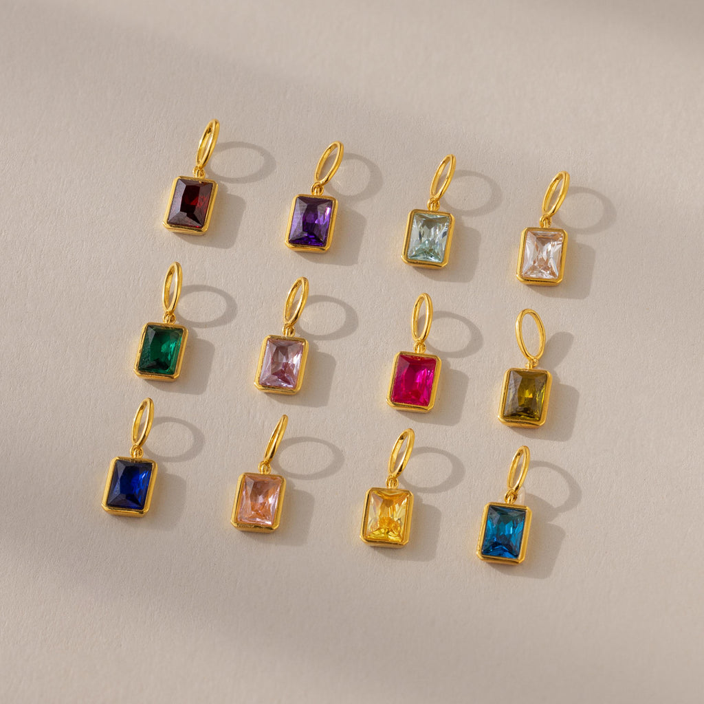 Twelve emerald birthstone charms in different stone colors