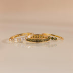 Three gold rings displayed flat with peridot and diamond designs, arranged side by side.