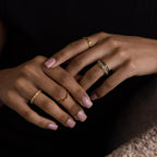 Model’s hands styled with multiple rings, featuring the peridot and diamond ring stack as the centerpiece.