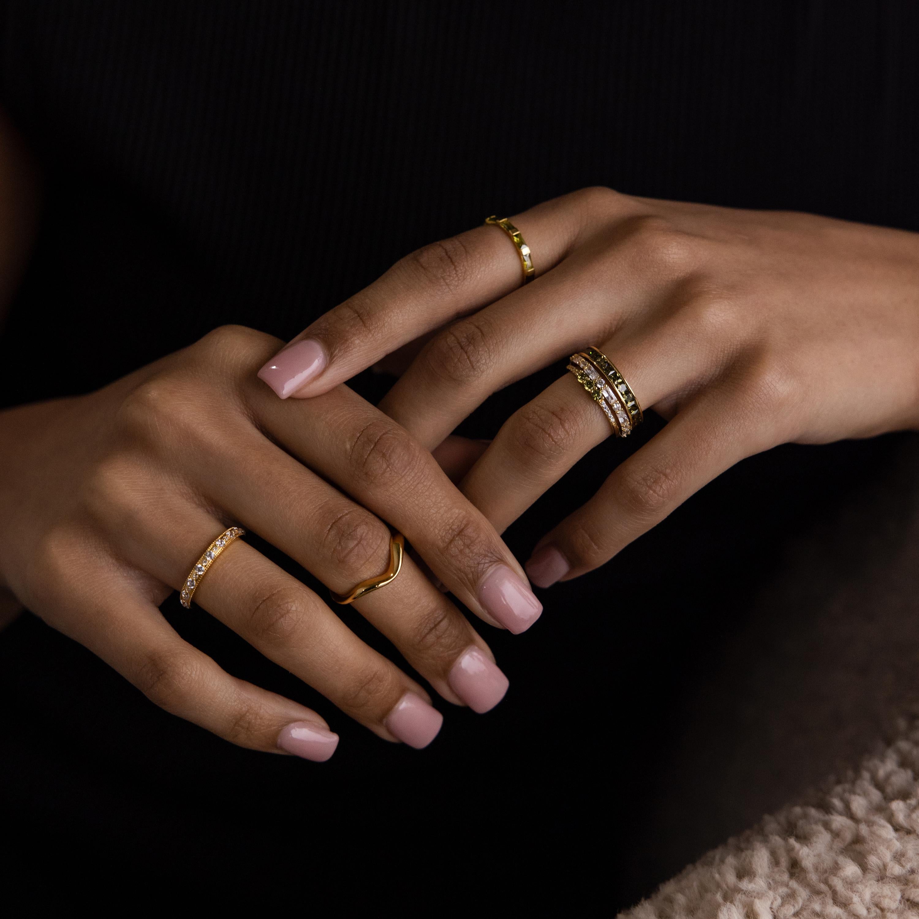 Model’s hands styled with multiple rings, featuring the peridot and diamond ring stack as the centerpiece.